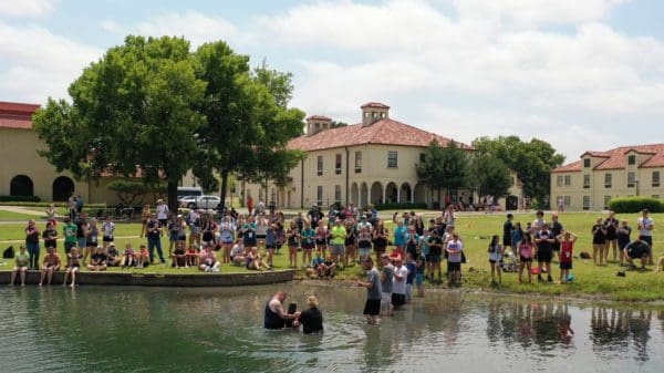 Students being baptized in pond