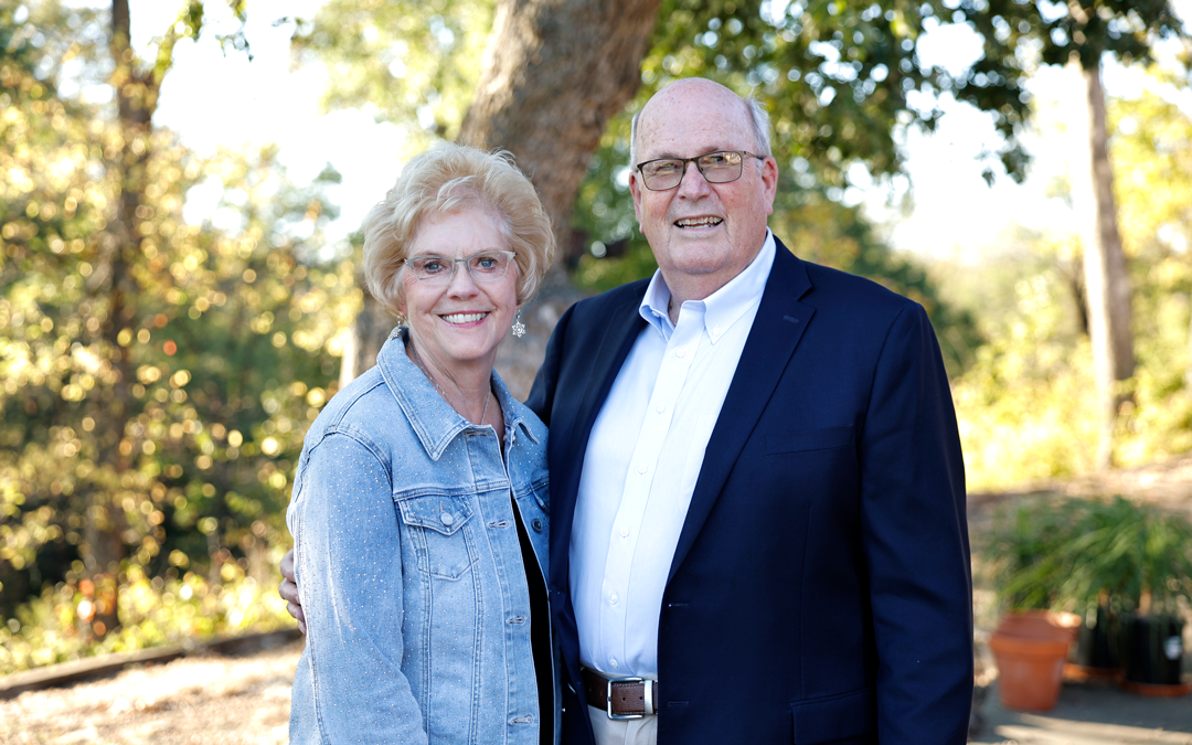 Ward and Joetta Koeser posing in front of a tree smiling